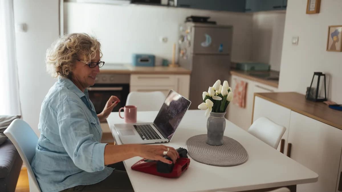 Older adult and relative reviewing an online account on a laptop at a kitchen table