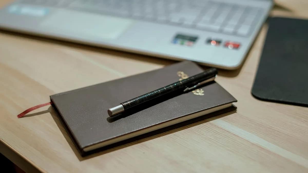 Illustration of a premium dark gray laptop with a glowing green circuit-pattern screen on a desk
