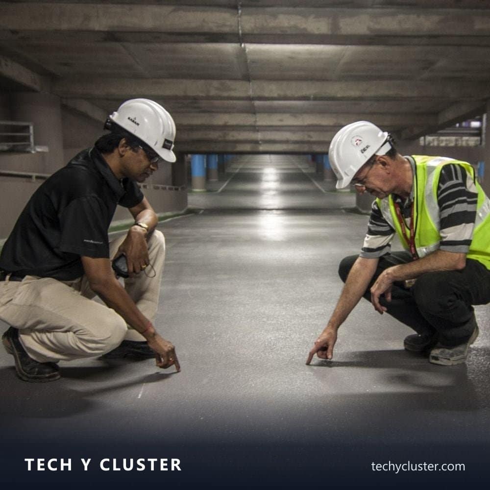 Two engineers in hard hats inspecting a floor