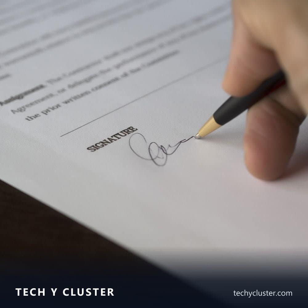Hand signing a document with a pen