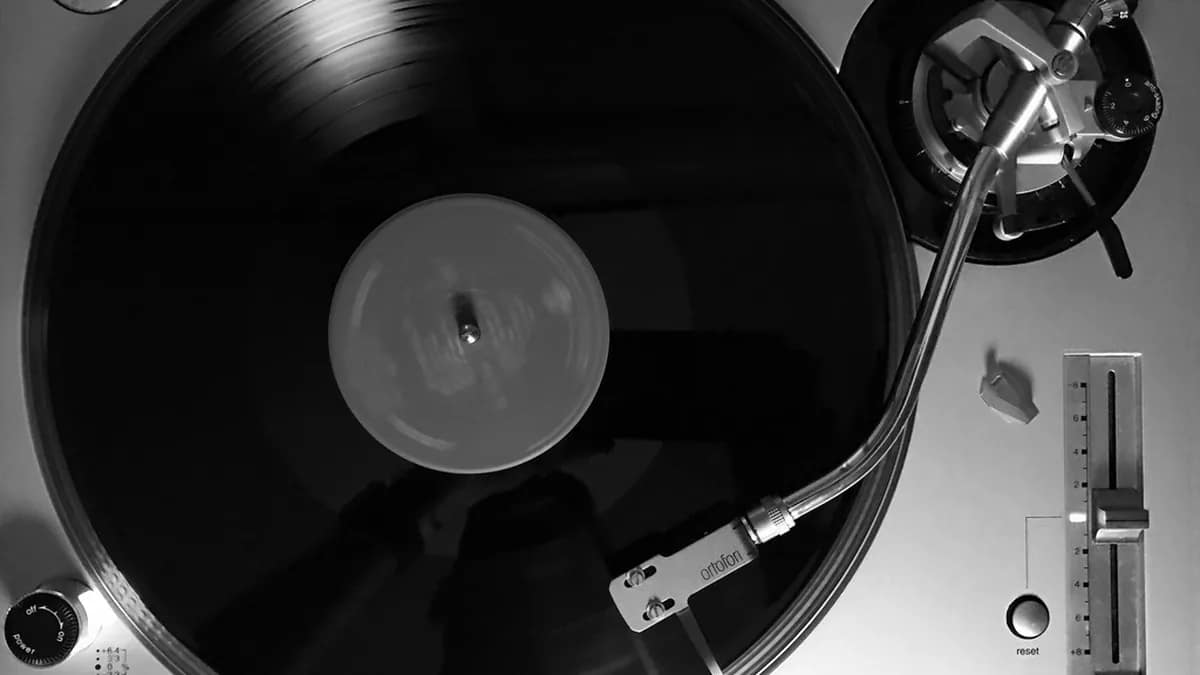 Illustration of a vinyl record whose grooves turn into digital waveforms and data streams