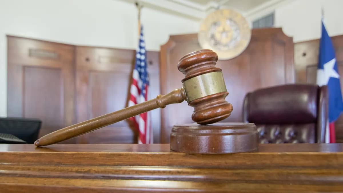 A judge's gavel resting on law books in a courtroom